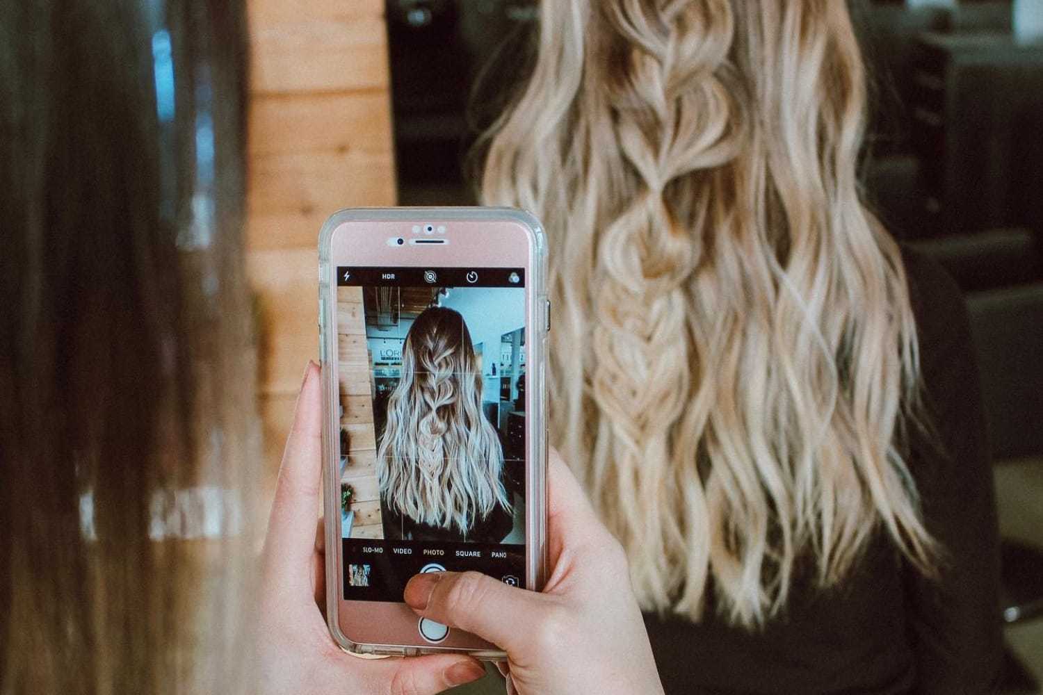 Blonde hair with loose waves being photographed in a salon setting.